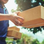 Delivery man handing out a box.